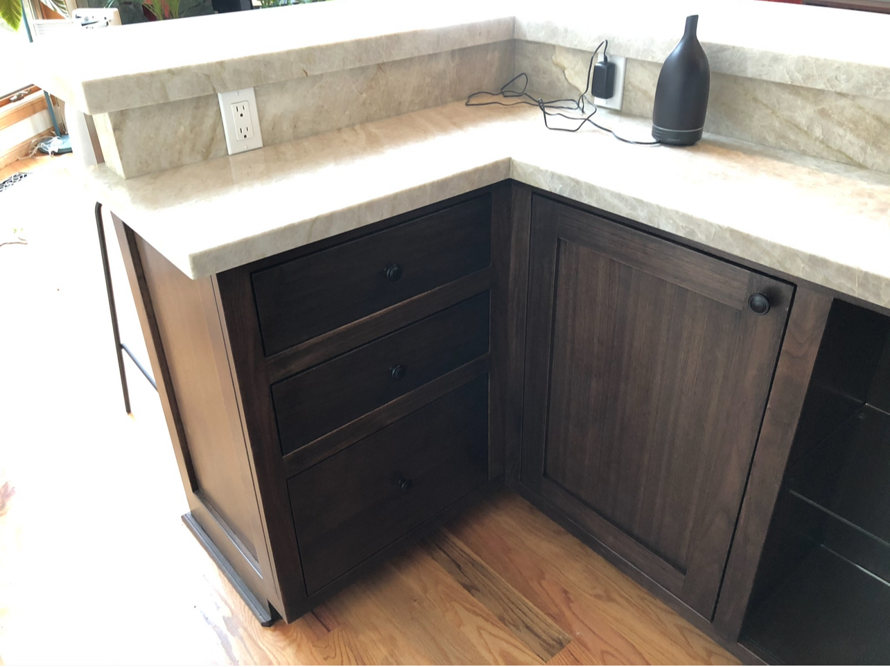Close-up of custom-built dark wood cabinet drawers with a light-colored countertop above, showcasing the detail by Mills Builds Inc. in Humboldt County, California.
