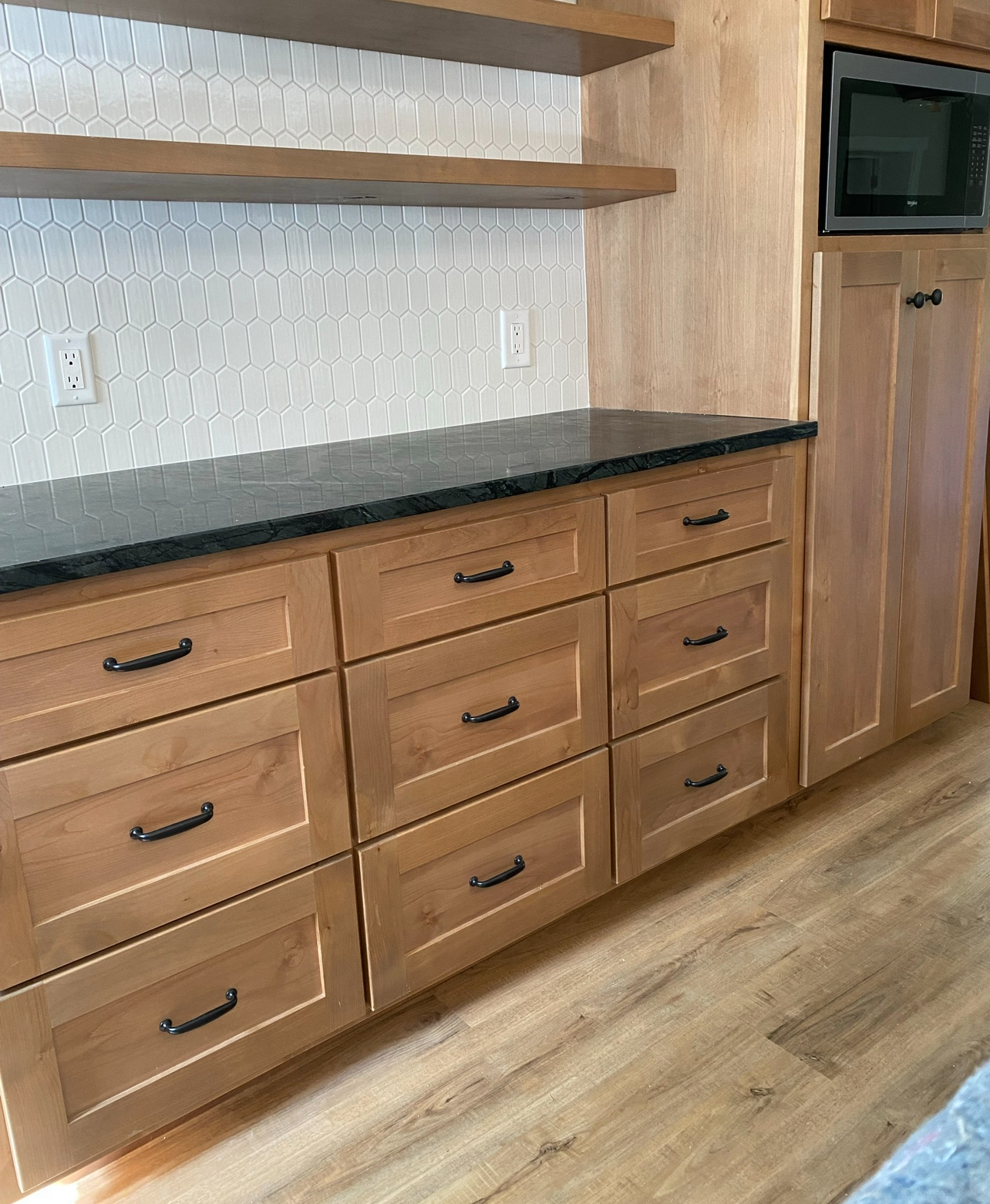 Close-up of custom-built wooden kitchen drawers with sleek black handles, showcasing the craftsmanship of Mills Builds Inc. in Humboldt County, California.