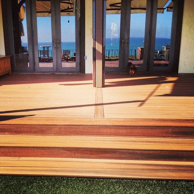Expansive wooden deck with steps leading towards French doors and a stunning ocean view in Humboldt County, California.