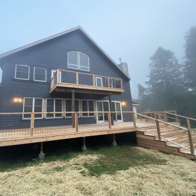 Large, multi-level wooden deck with modern wire railing, custom-built by Mills Builds Inc. for a home in Humboldt County, California.