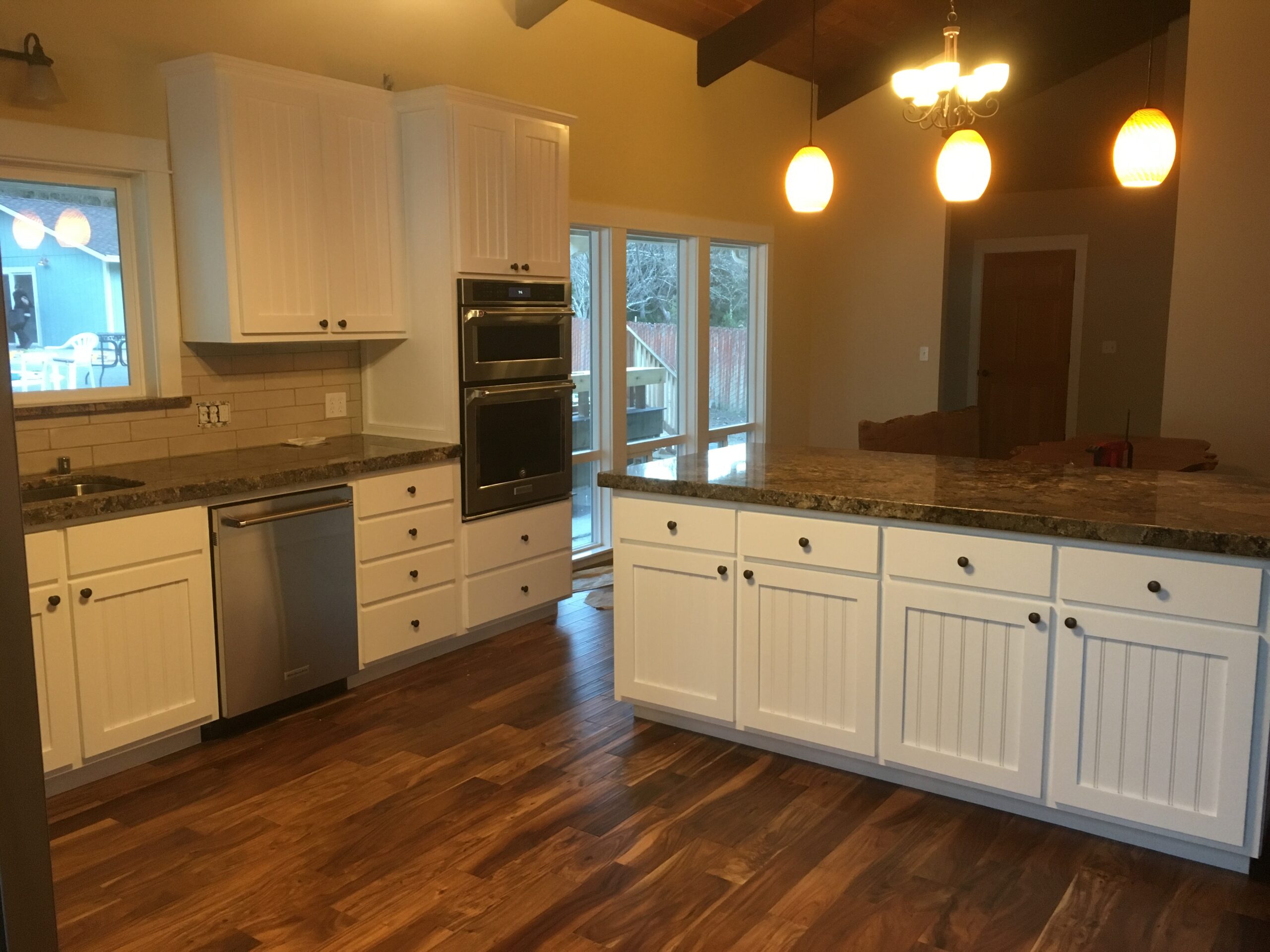 Kitchen remodel by Mills Builds IncCustom Cabinets with white cabinets and large granite island